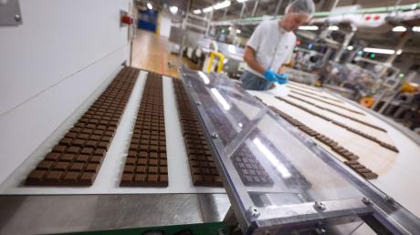Schokoladentafeln liegen in der Produktion am Hauptsitz der Alfred Ritter GmbH & Co. KG, auf einem Laufband.