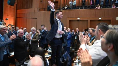 Manuel Hagel, Kandidat für den Landesvorsitz der CDU Baden-Württemberg, winkt beim Landesparteitag der CDU Baden-Württemberg nach seiner auf einem Stuhl stehend den Delegierten zu. Nach dem angekündigten Rückzug von T.Strobl will Manuel Hagel für den Landesvorsitz kandidieren.