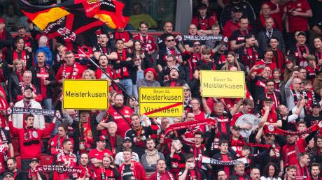 Leverkusener Fans halten Schilder mit der Aufschrift „Meisterkusen“ in die Höhe.