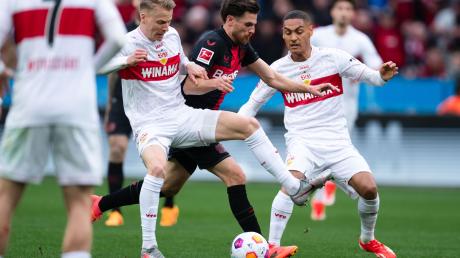 Leverkusens Jonas Hofmann (M) kämpft mit Stuttgarts Deniz Undav (l) und Enzo Millot um den Ball.