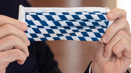 Sogar beim Mundschutz geht der Freistaat Bayern eigene Wege: Ministerpräsident Markus Söder präsentierte am Donnerstag ganz stilecht eine Maske mit weiß-blauen Rauten.