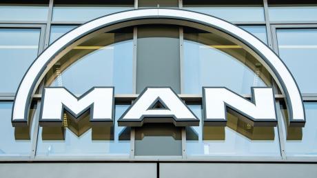 Das MAN Logo hängt an der Fassade eines Bürogebäudes.