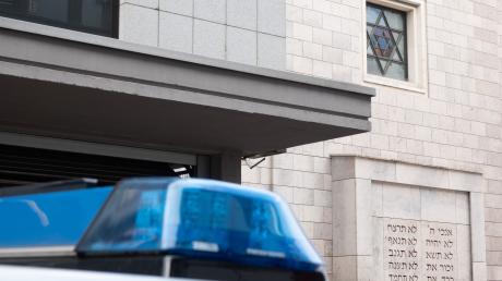 Ein Polizeiauto steht vor einer Synagoge.