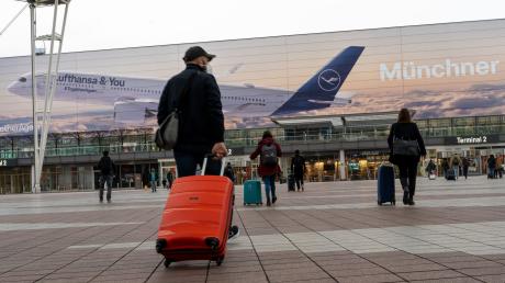 Flugpassagiere gehen zum Abflugterminal 2 des Flughafen München.