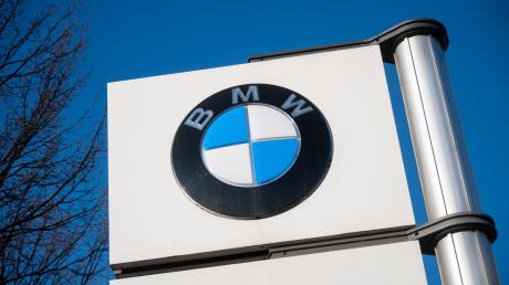 Das BMW-Logo ist vor einem Werk zu sehen.