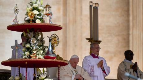 Papst Franziskus (l) sitzt neben den Reliquien von zehn der neuen Heiligen, deren Heiligsprechungsmesse er feiert.