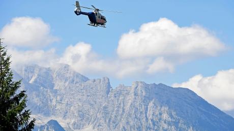 Ein Hubschrauber der Polizei fliegt über die Berchtesgadener Berge.