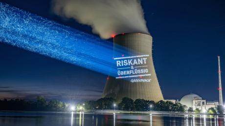 Greenpeace-Aktivisten projizieren «Riskant & überflüssig» an den Kühlturm am Kernkraftwerk Isar 2.
