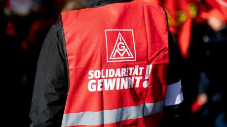 Ein Teilnehmer einer Kundgebung der IG Metall trägt eine rote Weste mit der Aufschrift «Solidarität gewinnt!».