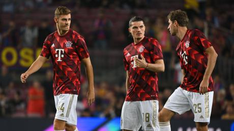 Münchens Josip Stanisic (l-r), Marcel Sabitzer und Thomas Müller beim Aufwärmen vor dem Spiel.