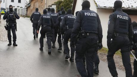 Einsatzkräfte der Polizei laufen während einer Durchsuchung zum Jagdschloss Waidmannsheil.