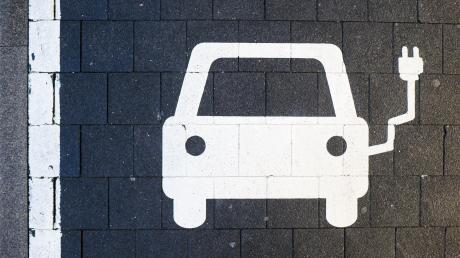 Ein Symbol markiert einen Parkplatz an einer Ladesäule für Elektroautos.