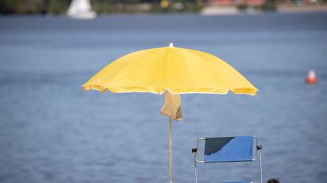 Ein Sonnenschirm steht an einem Strand am Altmühlsee.