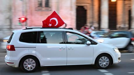 Ein Auto mit einer türkischen Flagge fährt über die Ludwigstraße, um den Ausgang der Wahl in der Türkei zu feiern.