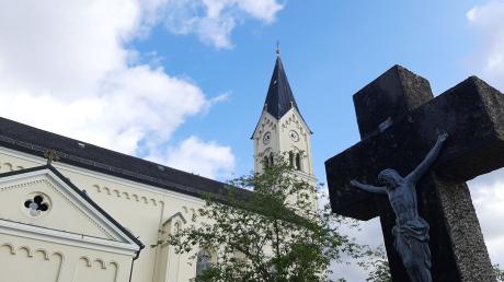 Ein Kreuz steht vor der Kirche St. Nikolaus in Garching an der Alz.