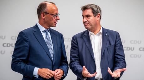 Markus Söder (CSU, r), Ministerpräsident von Bayern und CSU-Vorsitzender, spricht mit Friedrich Merz, CDU Bundesvorsitzender.