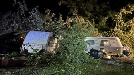 Bäume liegen nach einem Unwetter auf Campingwagen auf einem Campingplatz.