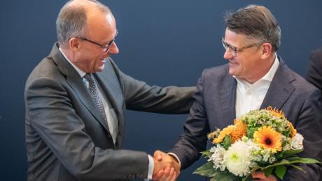 Boris Rhein (r) bekommt Blumen von Friedrich Merz nach den Landtagswahlen in Bayern und Hessen.