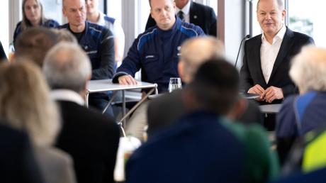 Bundeskanzler Olaf Scholz (r, SPD) spricht im BMW-Werk bei einem Besuch mit den Mitarbeitern.