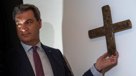 Bayerns Ministerpräsident Markus Söder (CSU), hängt ein Kreuz im Eingangsbereich der Bayerischen Staatskanzlei auf. Über den gut fünf Jahre alten „Kreuzerlass“ wird jetzt am Bundesverwaltungsgericht in Leipzig verhandelt.