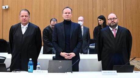 Der frühere Wirecard-Vorstandschef Markus Braun (M) steht zwischen seinen Anwälten im Gerichtssaal.