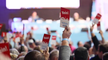 Mitglieder der AfD Bayern stimmen bei einer Abstimmung auf dem Landesparteitag im Hippodrom mit ihrer Nein-Karte gegen einen Antrag.