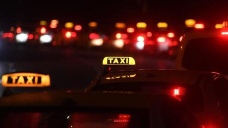 Zahlreiche Taxis stehen abends am Straßenrand.