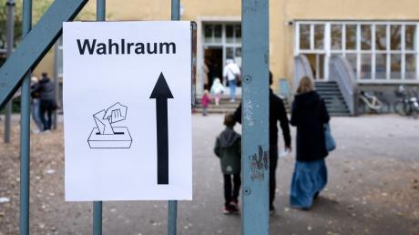 Ein Schild mit der Aufschrift «Wahlraum» hängt an einem Tor vor einem Wahllokal im Stadtteil München-Neuhausen.