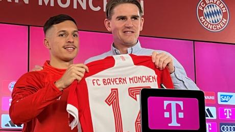 Der Sportdirektor des FC Bayern München, Christoph Freund (r), stellt bei einer Pressekonferenz den spanischen Fußballspieler Bryan Zaragoza vor und übergibt ihm das Trikot mit der Nummer 17.