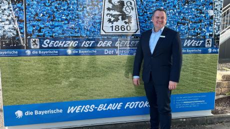 Oliver Mueller, neuer Geschäftsführer des TSV 1860 München, steht vor eine Fotowand.