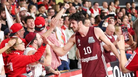 Der Münchener Leandro Bolmaro klatscht sich nach dem Sieg im Pokal-Halbfinale gegen die Bamberg Baskets mit den Fans ab.