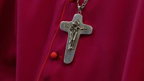 Ein Bischof trägt beim Eröffnungsgottesdienst der Frühjahrsvollversammlung der Deutschen Bischofskonferenz in der Hofkirche eine Kette mit Kreuz.