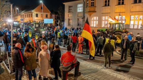 Demonstranten mit Deutschlandfahnen und Traktoren protestieren vor einer Parteiversammlung der Grünen.