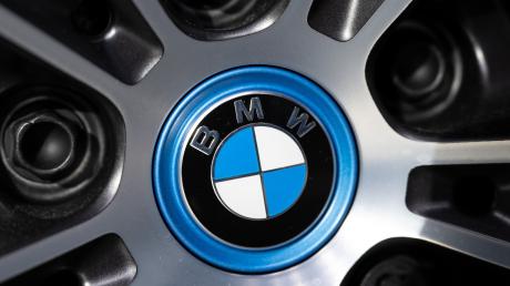 Das Logo von BMW ist an einer Felge von einem Auto zu sehen.