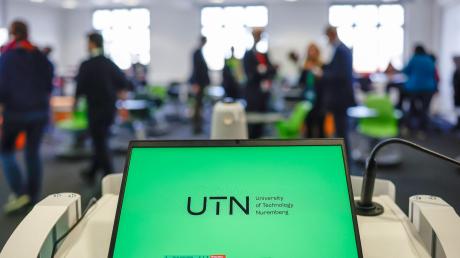 Ein Laptop mit dem Logo der UTN steht in einem Seminarraum der UTN (University of Technology Nuremberg).