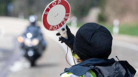 Eine Polizistin gibt während einer Verkehrskontrolle ein Signal zum Anhalten.