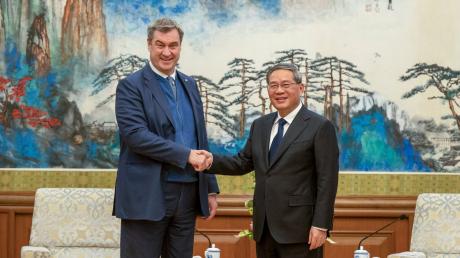 Markus Söder, (l, CSU) Ministerpräsident von Bayern, wird in Peking von LI Qiang (r), Premierminister der Volksrepublik China, empfangen.