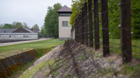 Ein Zaun und ein Wachturm sind an der Gedenkstätte des Konzentrationslagers Dachau zu sehen.
