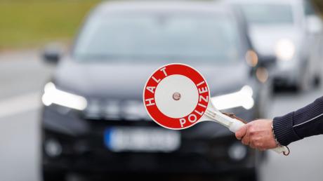 Ein Beamter der Bundespolizei stoppt bei der kontrolle des Einreiseverkehrs am deutsch-tschechischen Grenzübergang ein Auto.