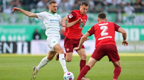 Der Fürther Dennis Srbeny (l) kämpft mit Filip Kaloc (M) und Boris Tomiak aus Kaiserslautern um den Ball.