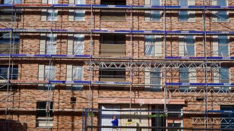 Ein Bauarbeiter vor einem auf ehemaligen Feldern errichteten Wohnblock im neuen Münchner Stadtteil Freiham.