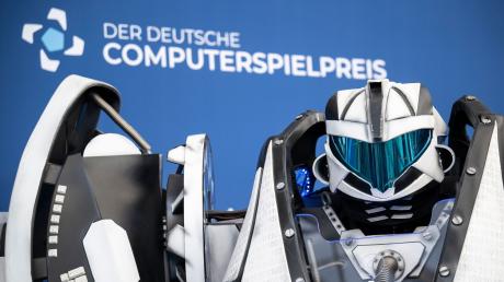 Der Gamescom Bot steht vor der Fotowand mit Schriftzug «Der Deutsche Computerspielpreis».