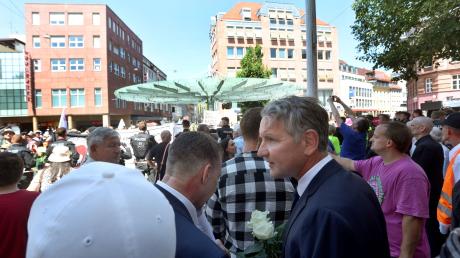 Björn Höcke steht am 25. Juni 2023 mit AfD-Sympathisanten vor Gegendemonstranten nahe einer Gedenkstele.