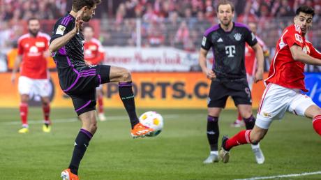 Thomas Müller (l) von Bayern München trifft den Ball zum 3:0.