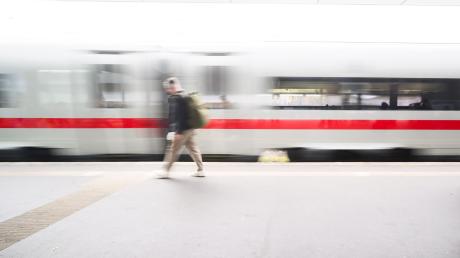 Ein Mann läuft auf einem Bahnsteig im Hauptbahnhof Hannover, während ein ICE einfährt (Aufnahme mit langer Verschlusszeit).