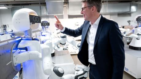 Markus Blume (CSU), Wissenschaftsminister von Bayern, schaut sich während der KI-Konferenz "AI.BAY 2023" in der KI.Fabrik des Munich Institute of Robotics and Machine Intelligence (MIRMI) der Technischen Universität München (TUM) die Roboter an.