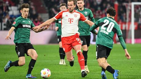 Münchens Harry Kane (M) kämpft gegen Stuttgarts Anthony Rouault (l) und Stuttgarts Leonidas Stergiou um den Ball.