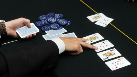 Der Dealer deutet beim Poker auf zwei aufgedeckte Karten.