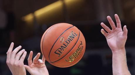 Spieler greifen nach einem Basketball.
