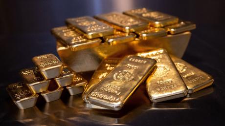 Goldbarren in unterschiedlicher Größe liegen bei einem Edelmetallhändler in einem Tresor auf einem Tisch.